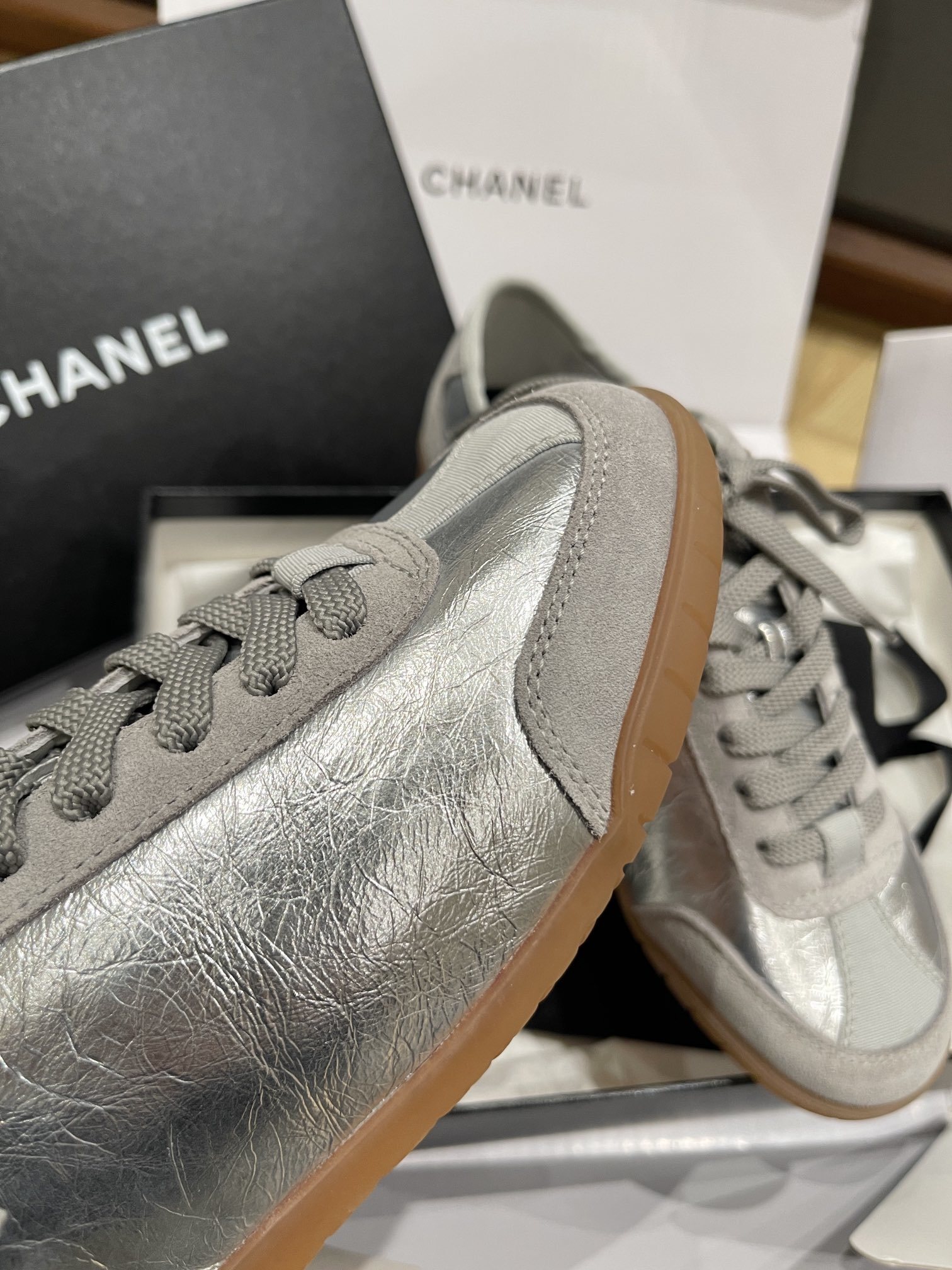 Authentic Chanel silver metallic leather sneakers with grey suede trim and gum soles in original packaging. - Hình 8