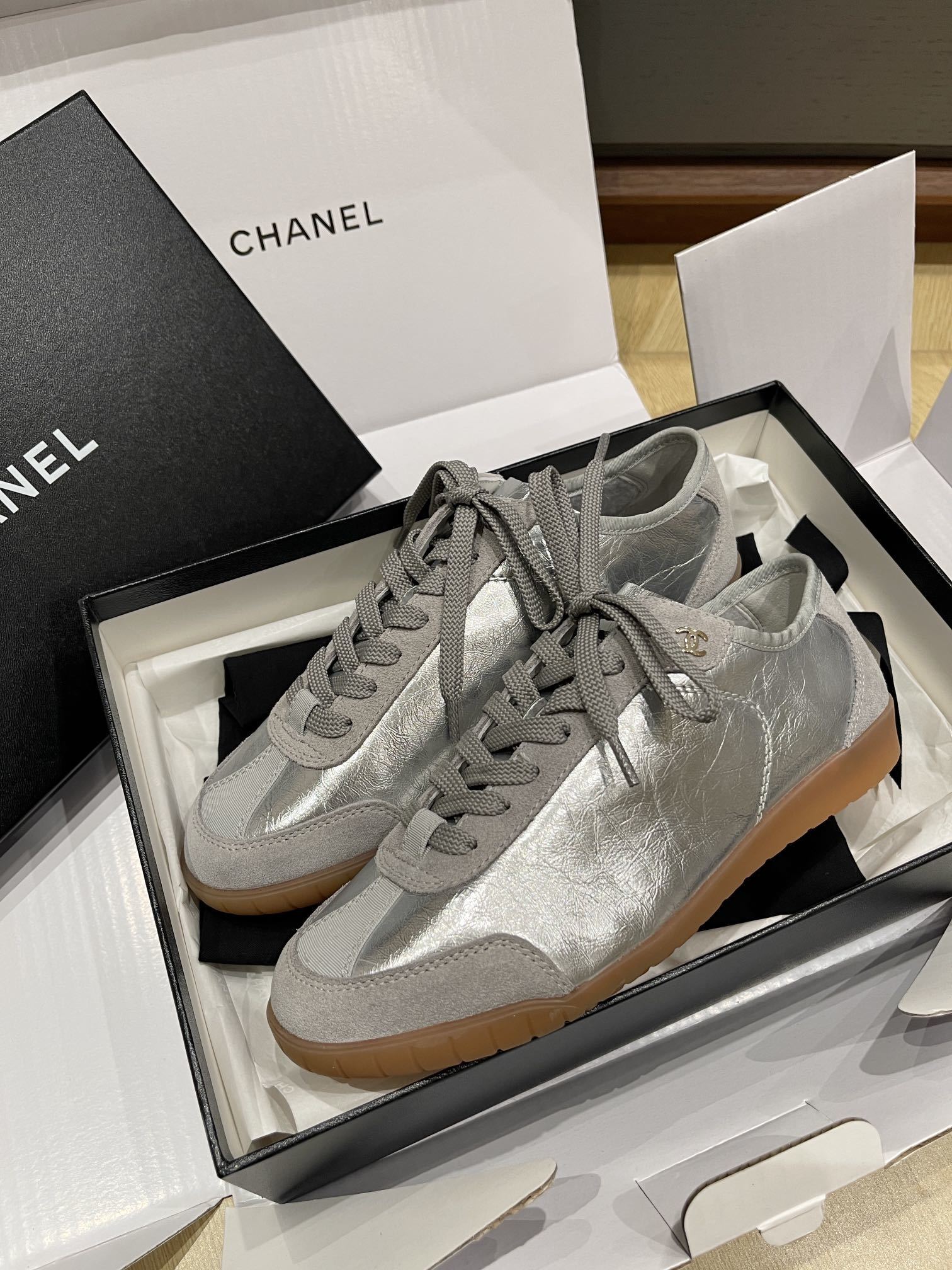 Authentic Chanel silver metallic leather sneakers with grey suede trim and gum soles in original packaging. - Hình 4