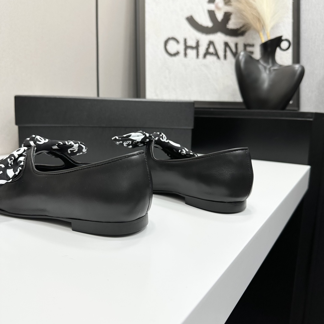 Elegant black Mary Jane ballet flats with a black and white logo pattern bow and fabric cap toe displayed on a luxury black box. - Hình 8