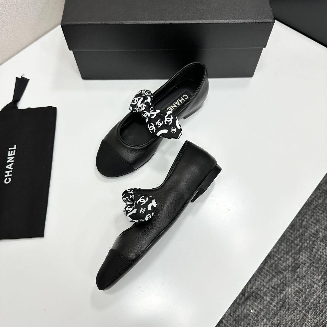 Elegant black Mary Jane ballet flats with a black and white logo pattern bow and fabric cap toe displayed on a luxury black box. - Hình 7