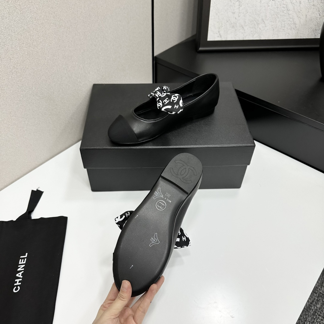 Elegant black Mary Jane ballet flats with a black and white logo pattern bow and fabric cap toe displayed on a luxury black box. - Hình 5