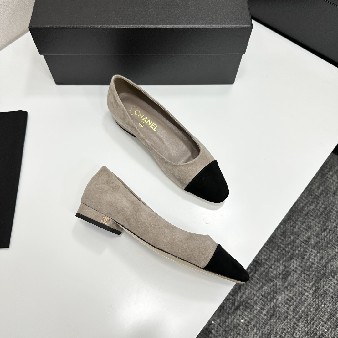 Chanel two-tone beige suede ballerina flats with black toe cap and gold CC logo on the heel sitting on a black box. - Hình 11