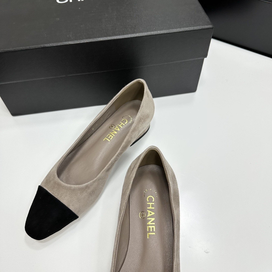 Chanel two-tone beige suede ballerina flats with black toe cap and gold CC logo on the heel sitting on a black box. - Hình 9