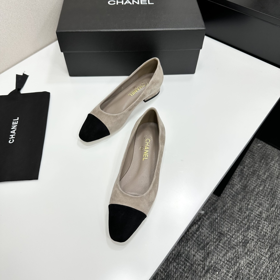 Chanel two-tone beige suede ballerina flats with black toe cap and gold CC logo on the heel sitting on a black box. - Hình 7