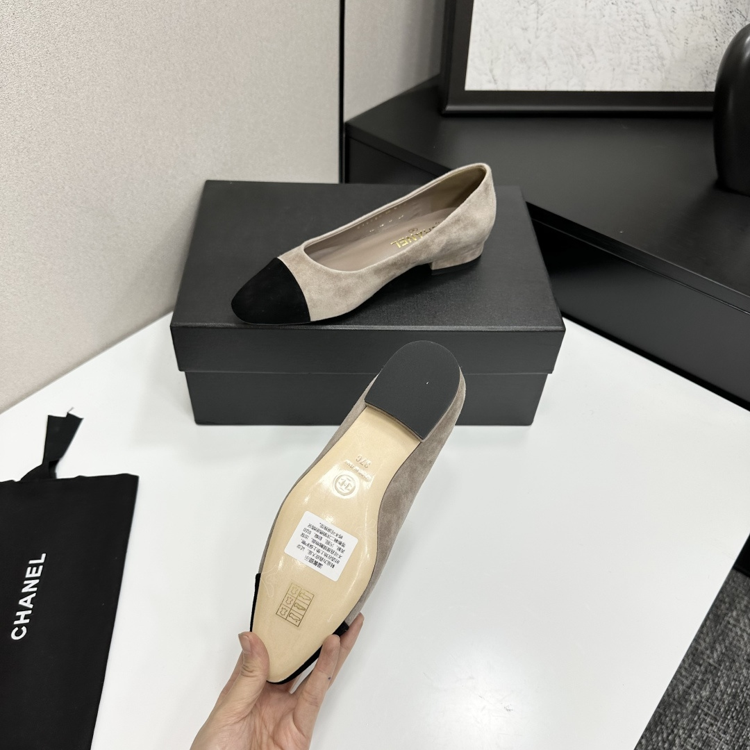 Chanel two-tone beige suede ballerina flats with black toe cap and gold CC logo on the heel sitting on a black box. - Hình 6