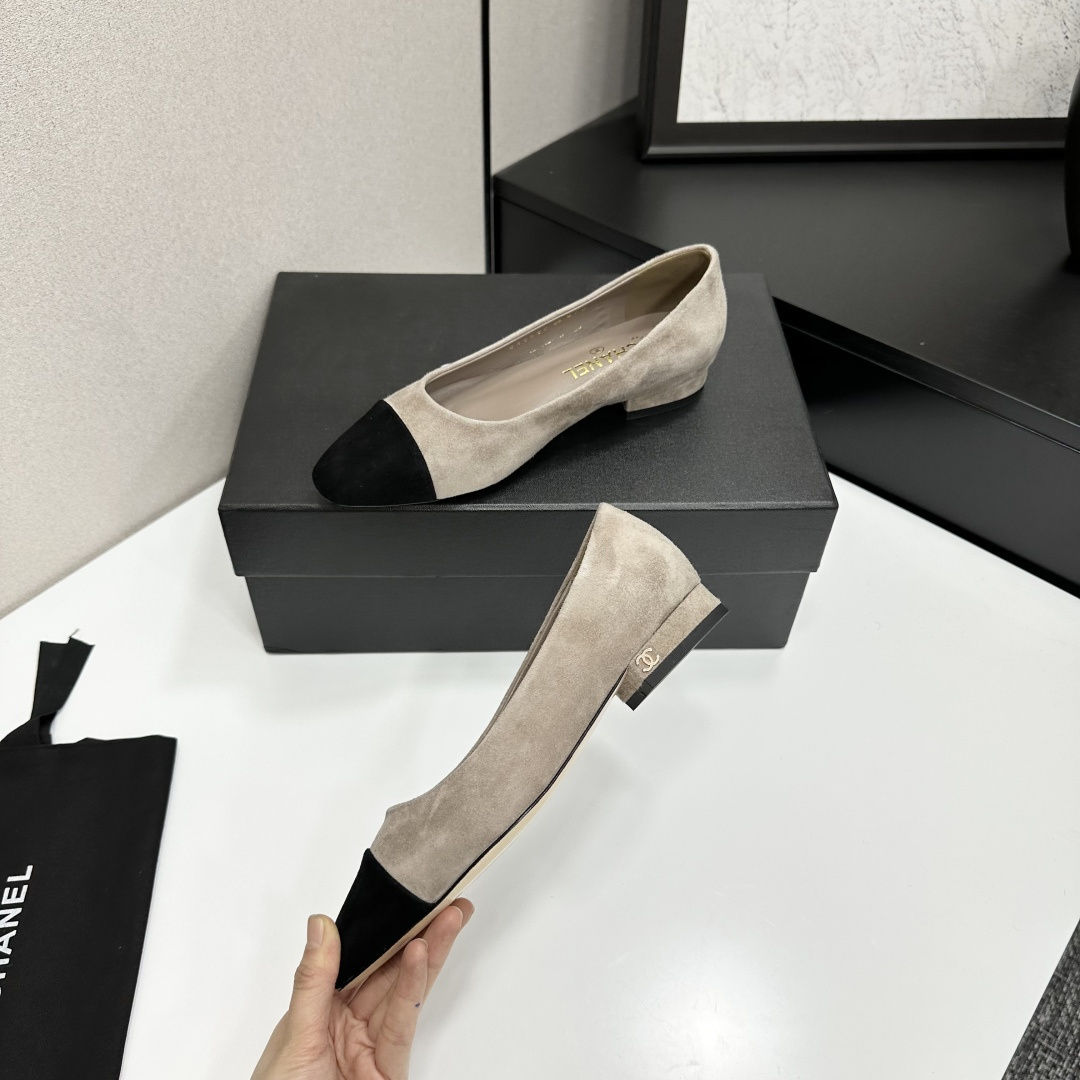 Chanel two-tone beige suede ballerina flats with black toe cap and gold CC logo on the heel sitting on a black box. - Hình 5