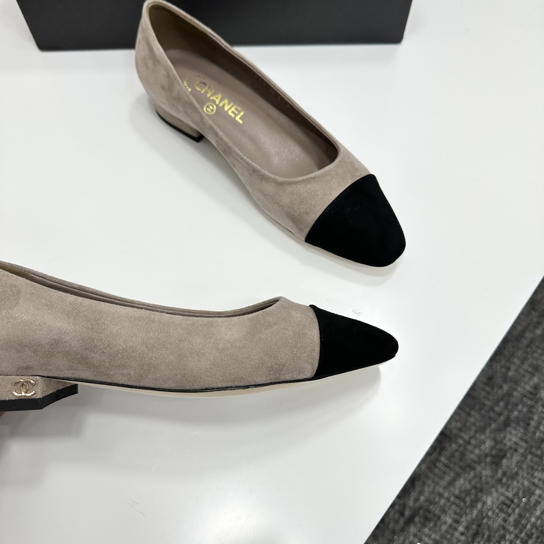 Chanel two-tone beige suede ballerina flats with black toe cap and gold CC logo on the heel sitting on a black box. - Hình 2