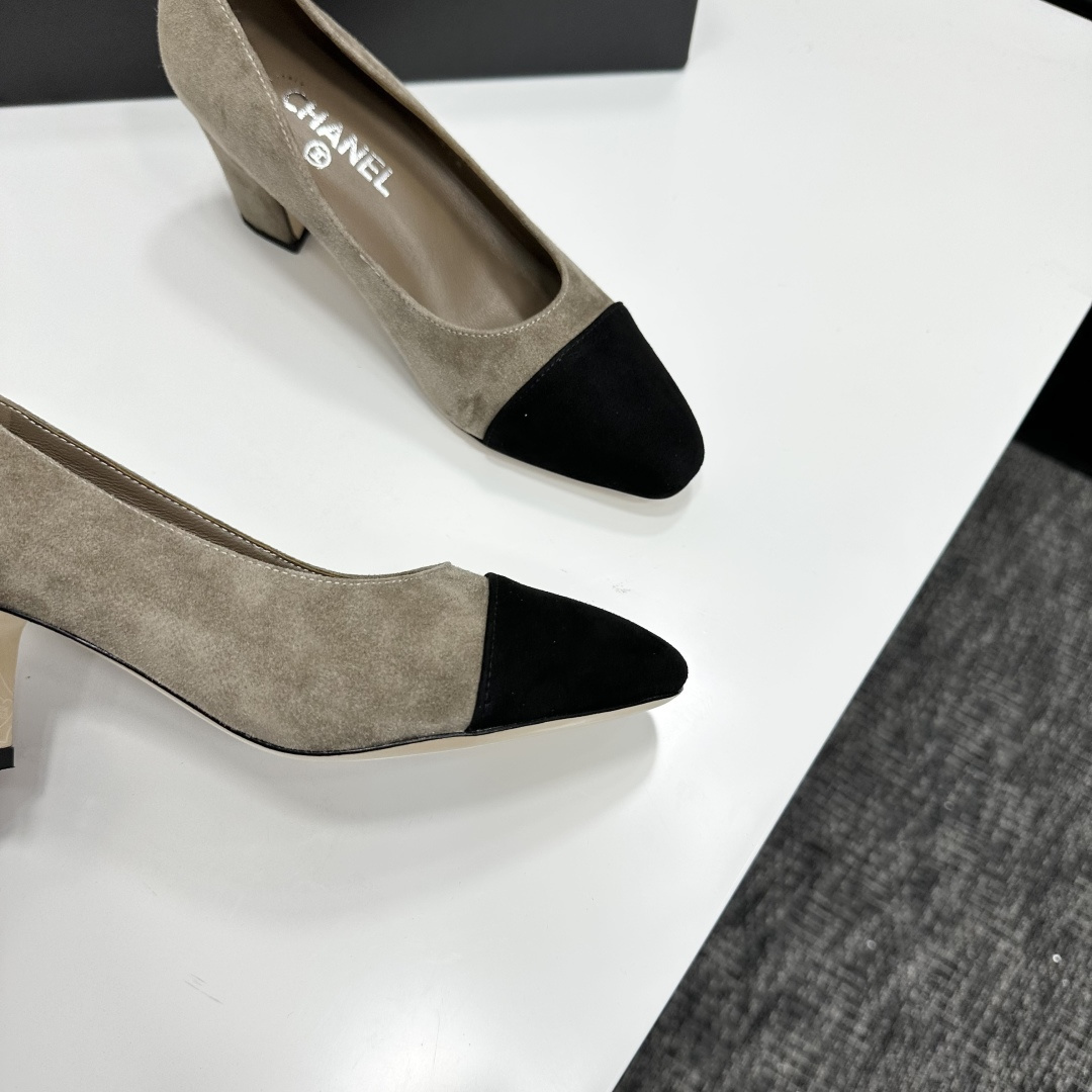 Chanel beige suede pumps with black cap-toes and block heels displayed on a black Chanel box. - Hình 10