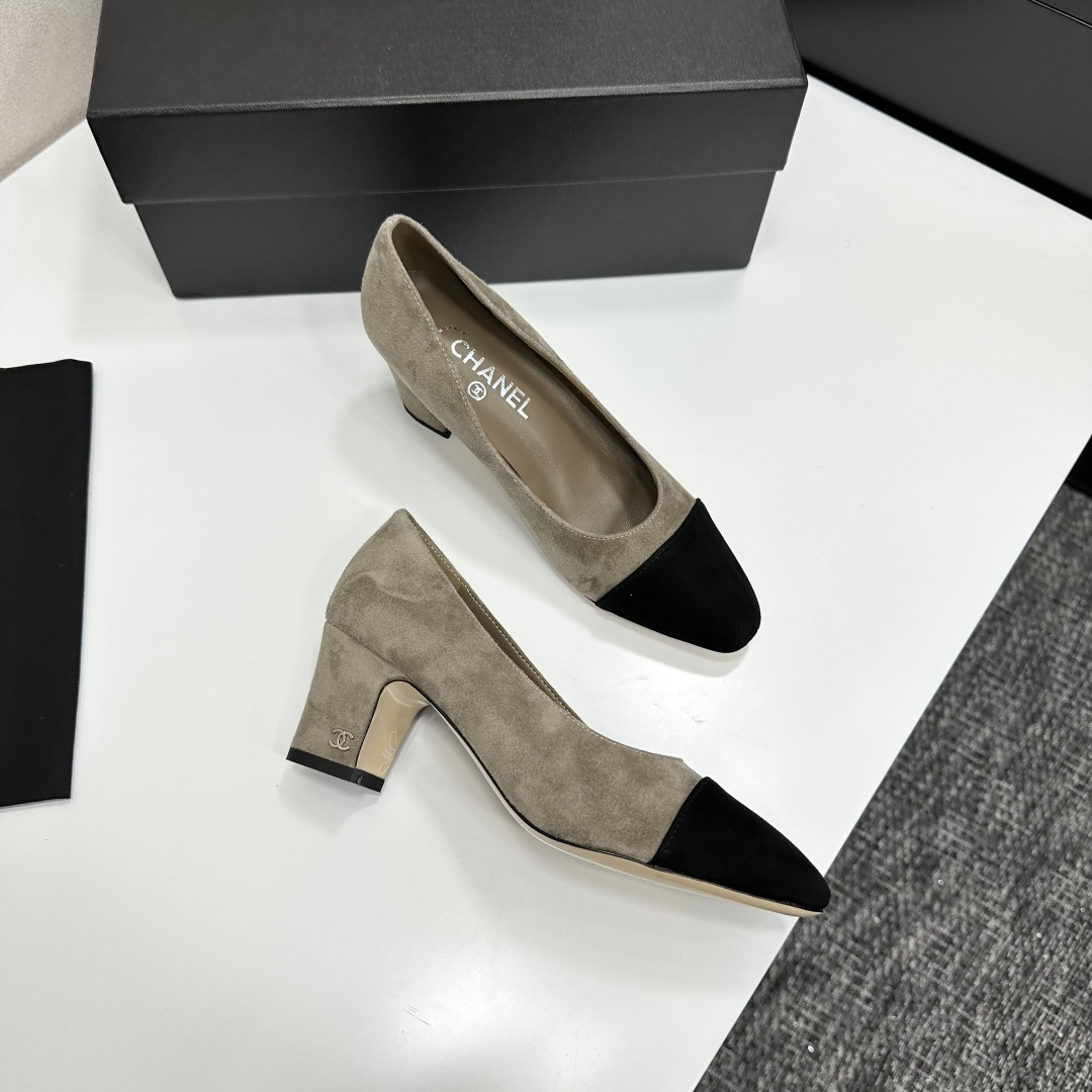 Chanel beige suede pumps with black cap-toes and block heels displayed on a black Chanel box. - Hình 9