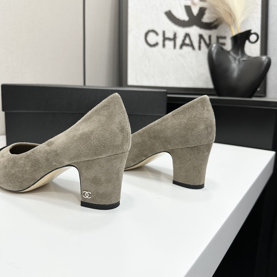 Chanel beige suede pumps with black cap-toes and block heels displayed on a black Chanel box. - Hình 8