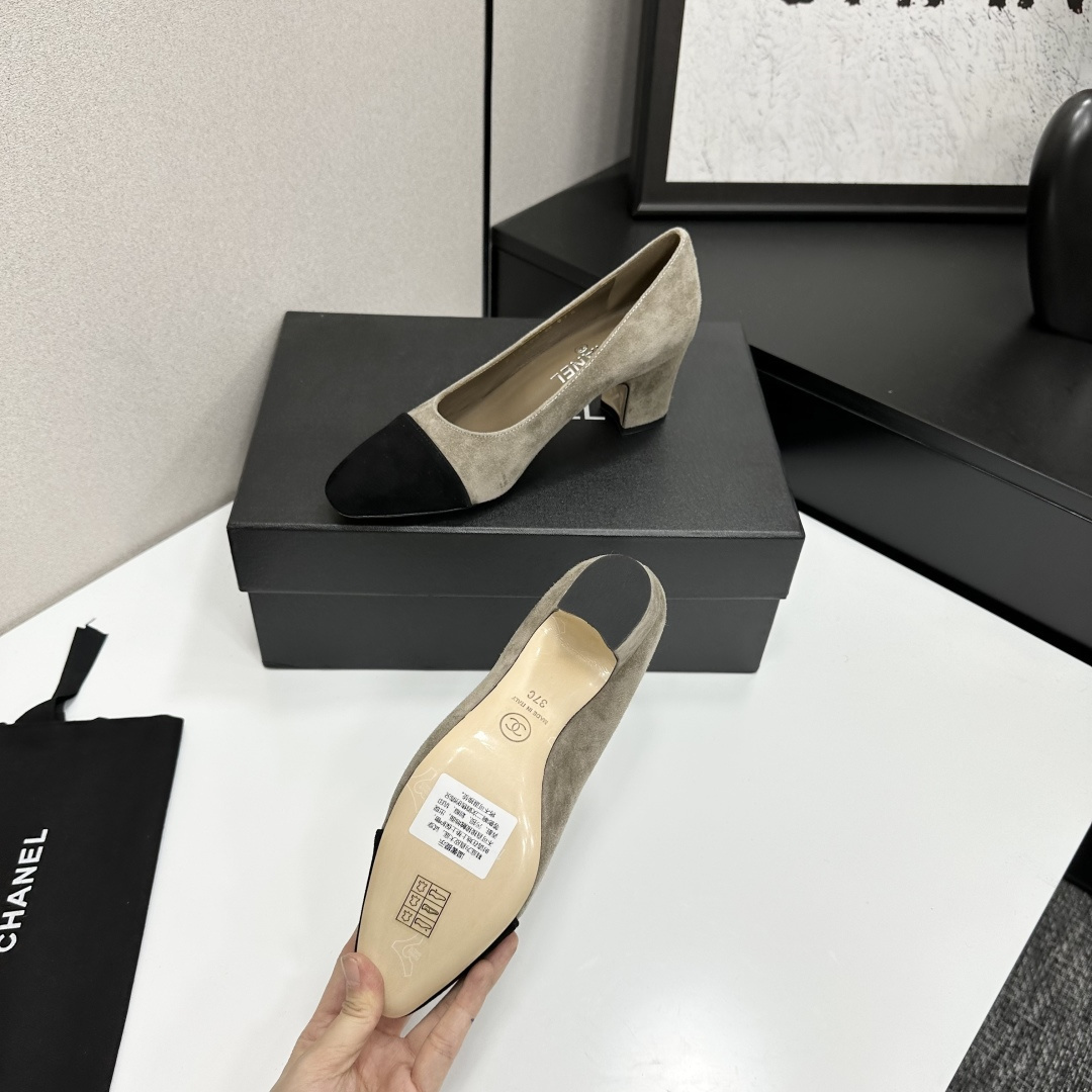 Chanel beige suede pumps with black cap-toes and block heels displayed on a black Chanel box. - Hình 5