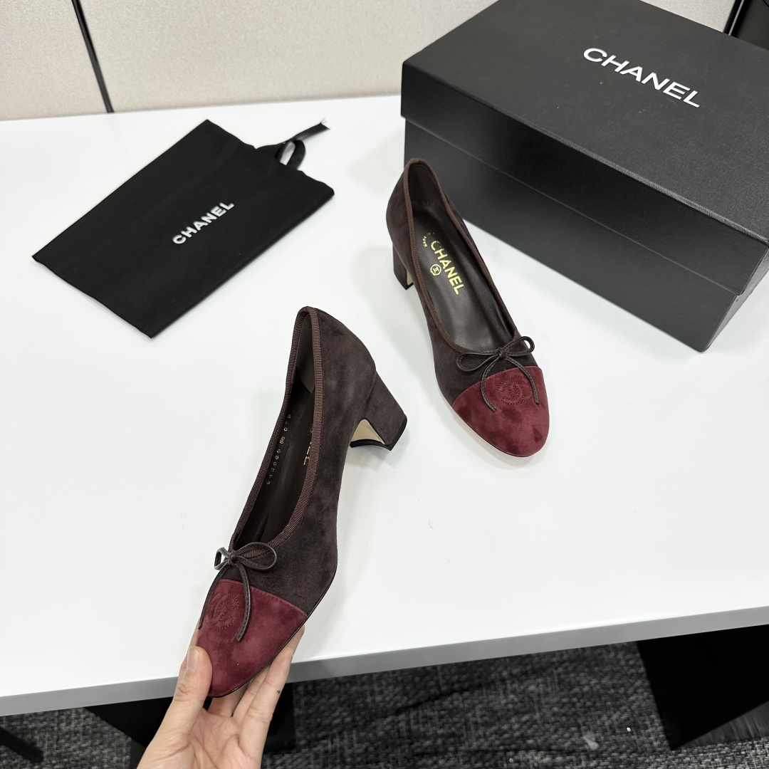 A pair of elegant two-tone suede block heel pumps in mocha brown and burgundy red with a small bow detail, displayed on a black shoe box. - Hình 9