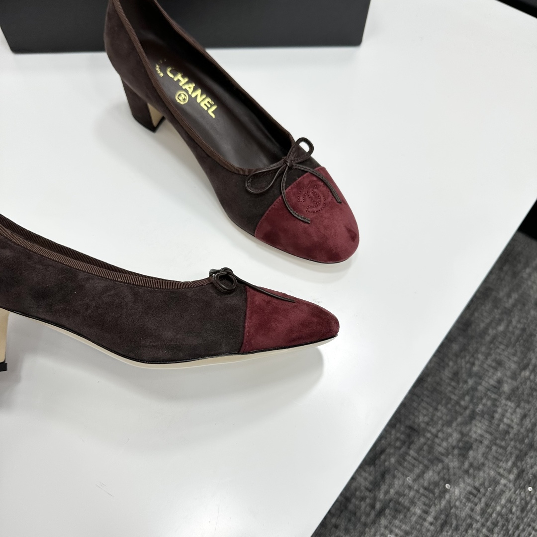 A pair of elegant two-tone suede block heel pumps in mocha brown and burgundy red with a small bow detail, displayed on a black shoe box. - Hình 8