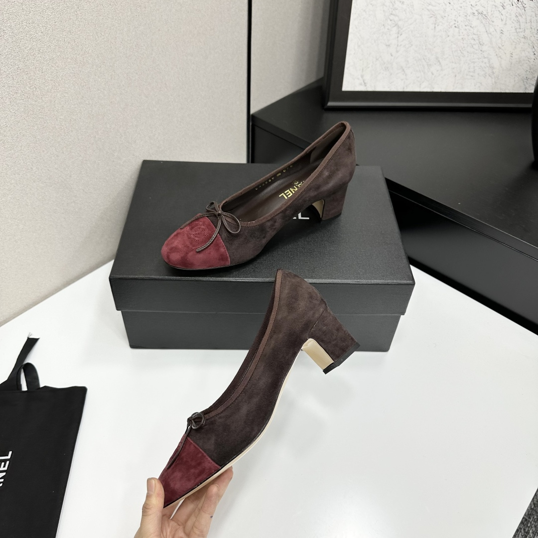 A pair of elegant two-tone suede block heel pumps in mocha brown and burgundy red with a small bow detail, displayed on a black shoe box. - Hình 3