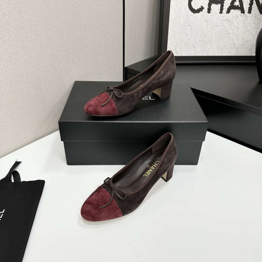A pair of elegant two-tone suede block heel pumps in mocha brown and burgundy red with a small bow detail, displayed on a black shoe box. - Hình 2
