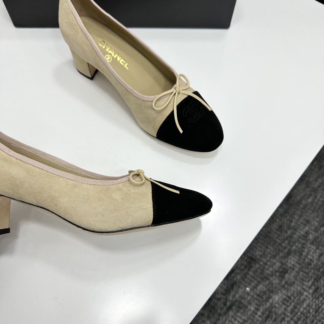 Elegant two-tone beige and black suede block heel pumps with a small bow detail on a black designer box. - Hình 8
