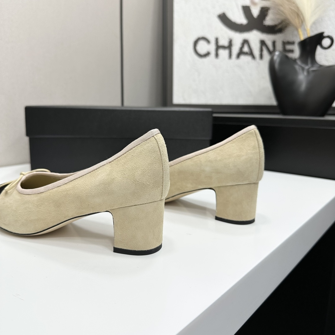 Elegant two-tone beige and black suede block heel pumps with a small bow detail on a black designer box. - Hình 6