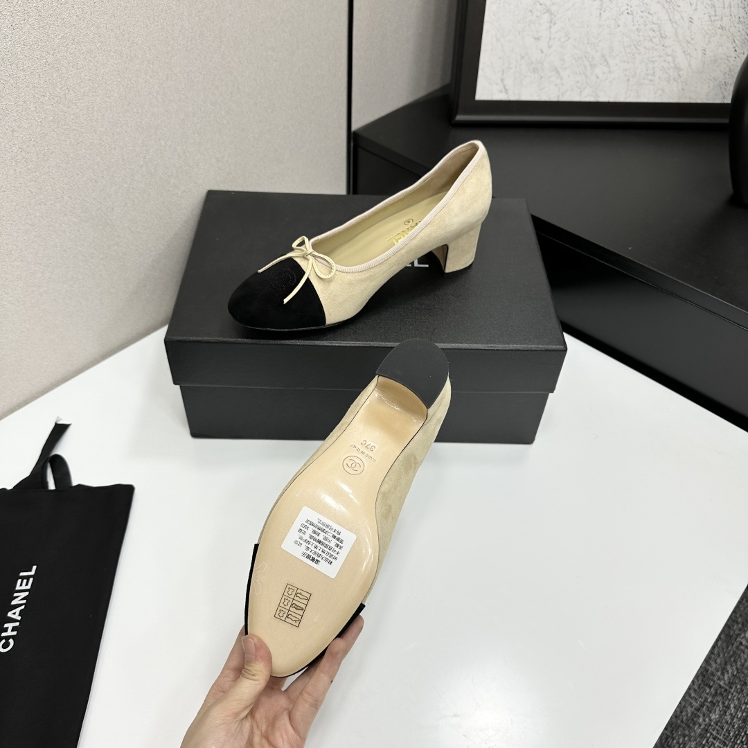 Elegant two-tone beige and black suede block heel pumps with a small bow detail on a black designer box. - Hình 4