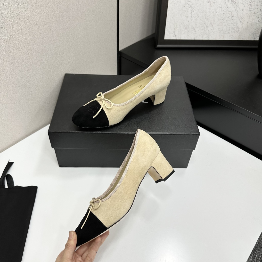 Elegant two-tone beige and black suede block heel pumps with a small bow detail on a black designer box. - Hình 3