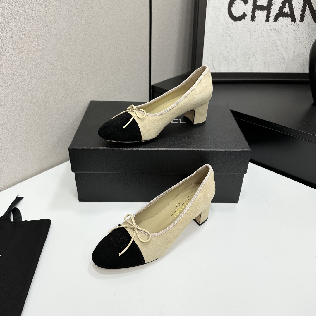 Elegant two-tone beige and black suede block heel pumps with a small bow detail on a black designer box. - Hình 2