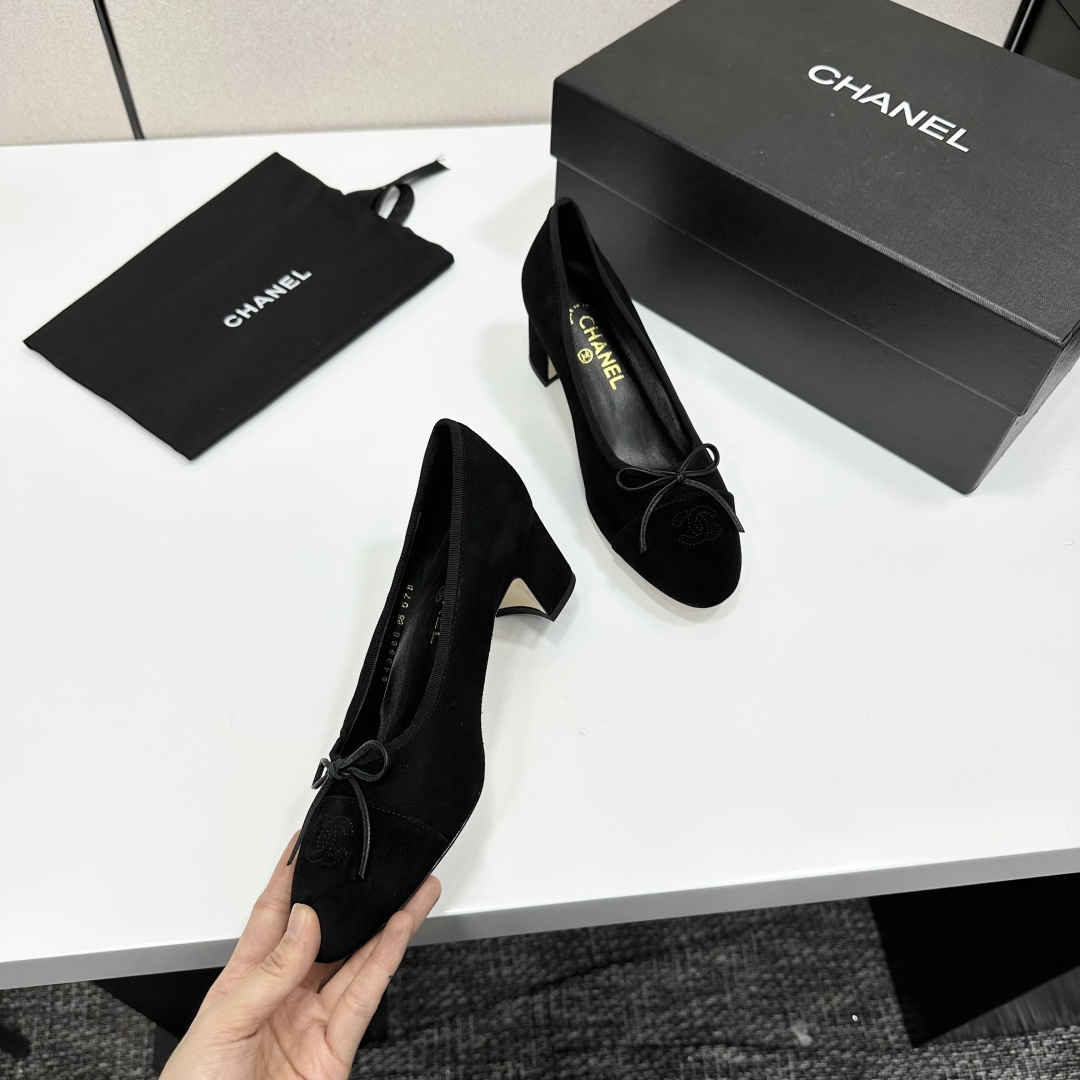 Pair of Chanel black suede block heel pumps with a delicate bow and interlocking CC logo on the toe cap sitting on a black box. - Hình 8