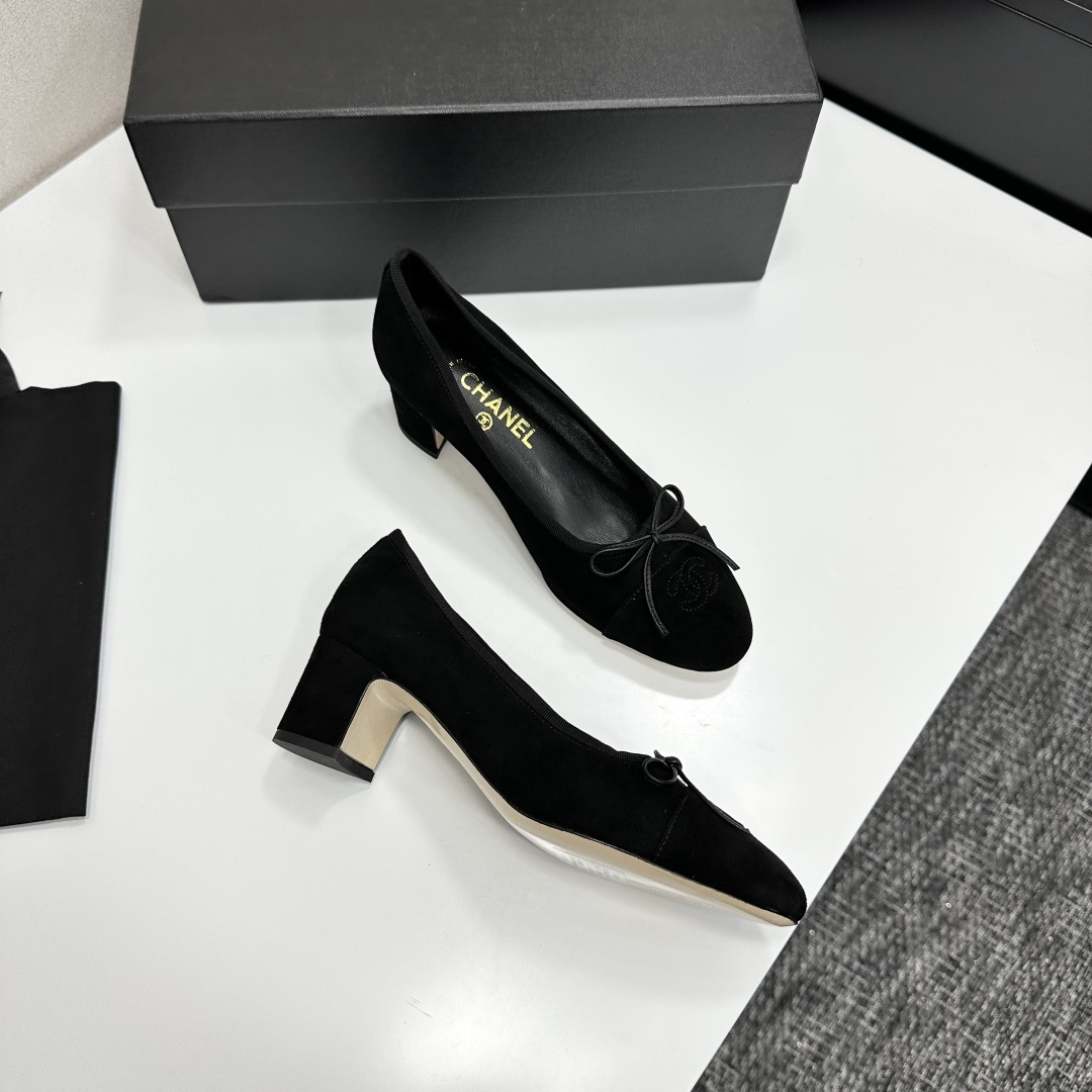Pair of Chanel black suede block heel pumps with a delicate bow and interlocking CC logo on the toe cap sitting on a black box. - Hình 7