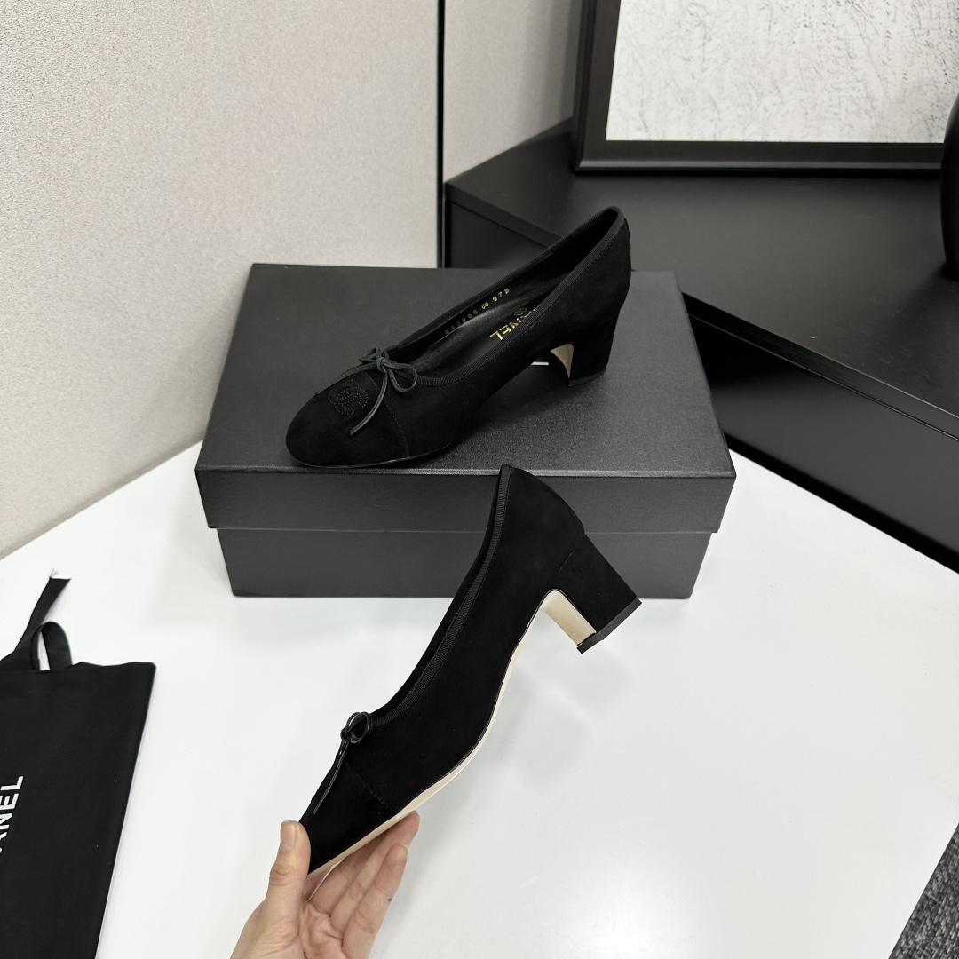 Pair of Chanel black suede block heel pumps with a delicate bow and interlocking CC logo on the toe cap sitting on a black box. - Hình 3