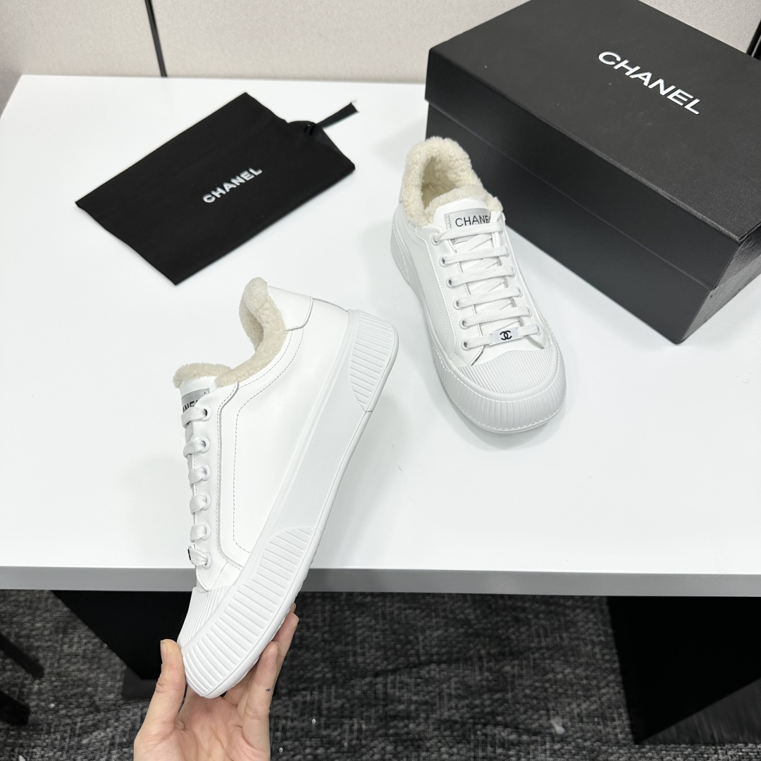 Luxury Chanel white leather sneakers with fuzzy cream lining and chunky platform soles displayed on a black designer box - Hình 2