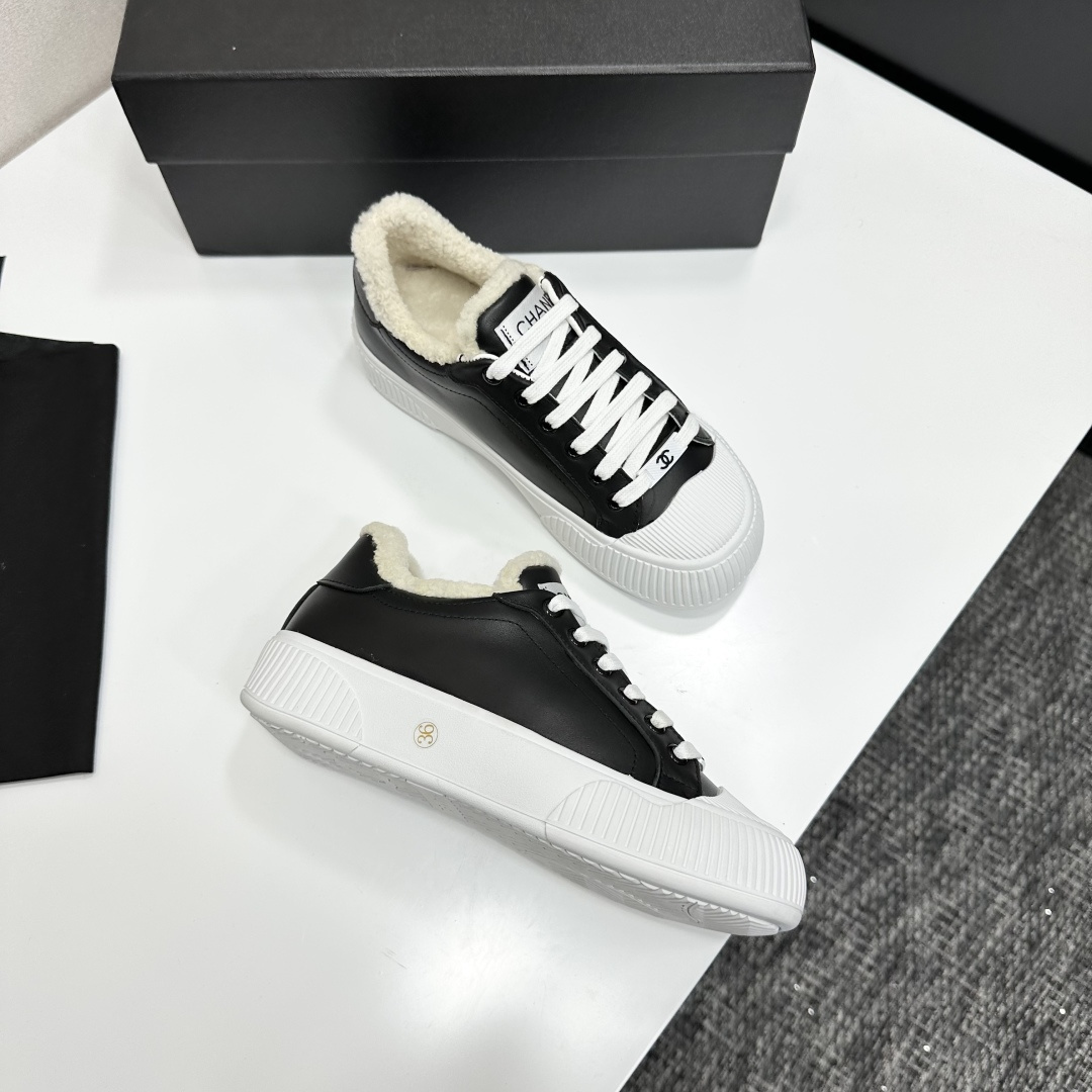 Side view of Chanel black leather sneakers with white shearling lining and chunky platform soles on a black display box. - Hình 9