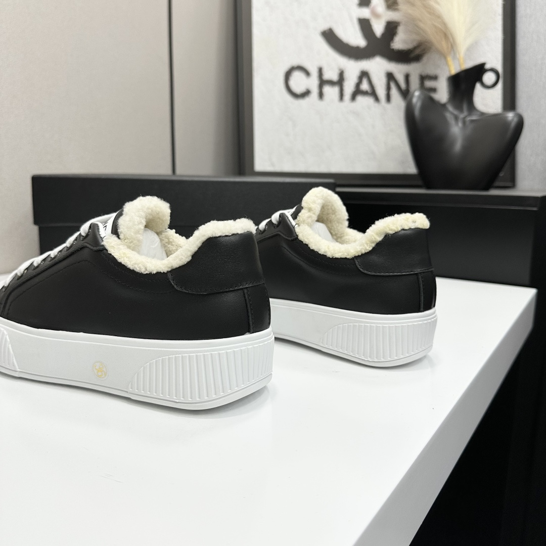 Side view of Chanel black leather sneakers with white shearling lining and chunky platform soles on a black display box. - Hình 8