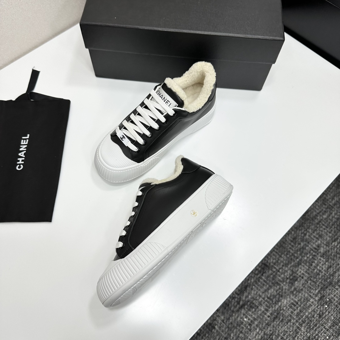 Side view of Chanel black leather sneakers with white shearling lining and chunky platform soles on a black display box. - Hình 7