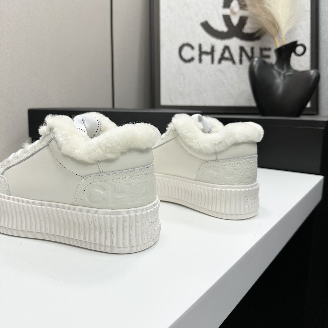 A pair of Chanel white platform sneakers with white fur lining and iconic logo details displayed on a black box. - Hình 6
