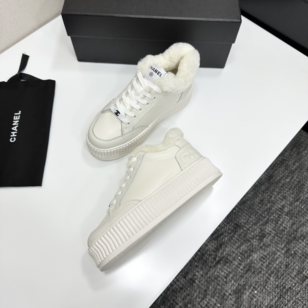 A pair of Chanel white platform sneakers with white fur lining and iconic logo details displayed on a black box. - Hình 5