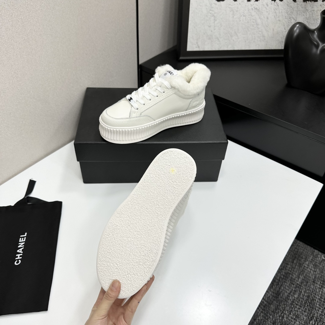 A pair of Chanel white platform sneakers with white fur lining and iconic logo details displayed on a black box. - Hình 4