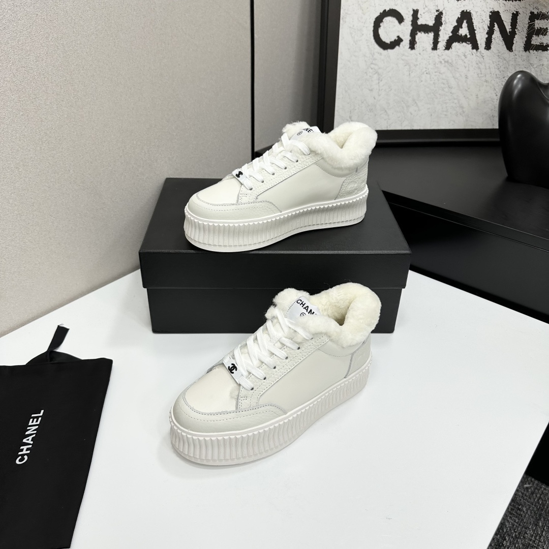 A pair of Chanel white platform sneakers with white fur lining and iconic logo details displayed on a black box. - Hình 2