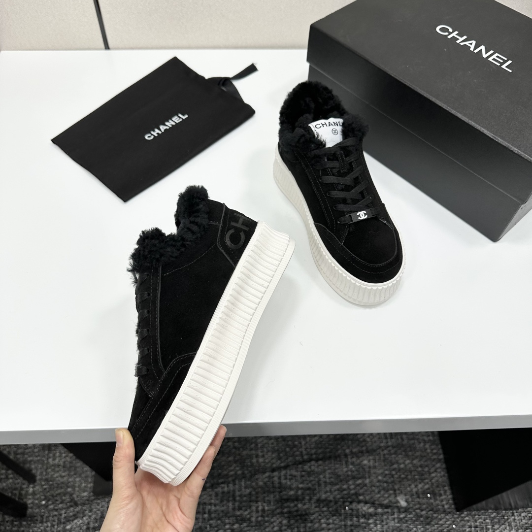 Luxury Chanel black suede sneakers with black fur trim and thick white ribbed platform soles on a black display box. - Hình 9
