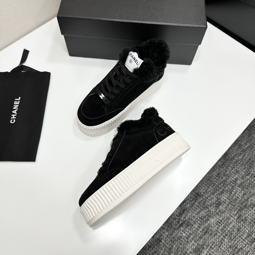Luxury Chanel black suede sneakers with black fur trim and thick white ribbed platform soles on a black display box. - Hình 5