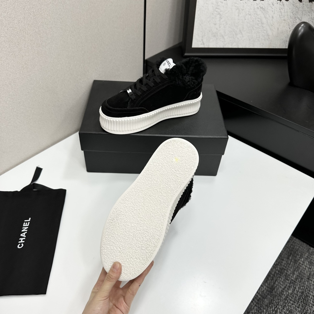 Luxury Chanel black suede sneakers with black fur trim and thick white ribbed platform soles on a black display box. - Hình 4