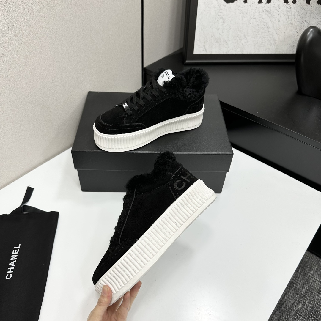 Luxury Chanel black suede sneakers with black fur trim and thick white ribbed platform soles on a black display box. - Hình 3