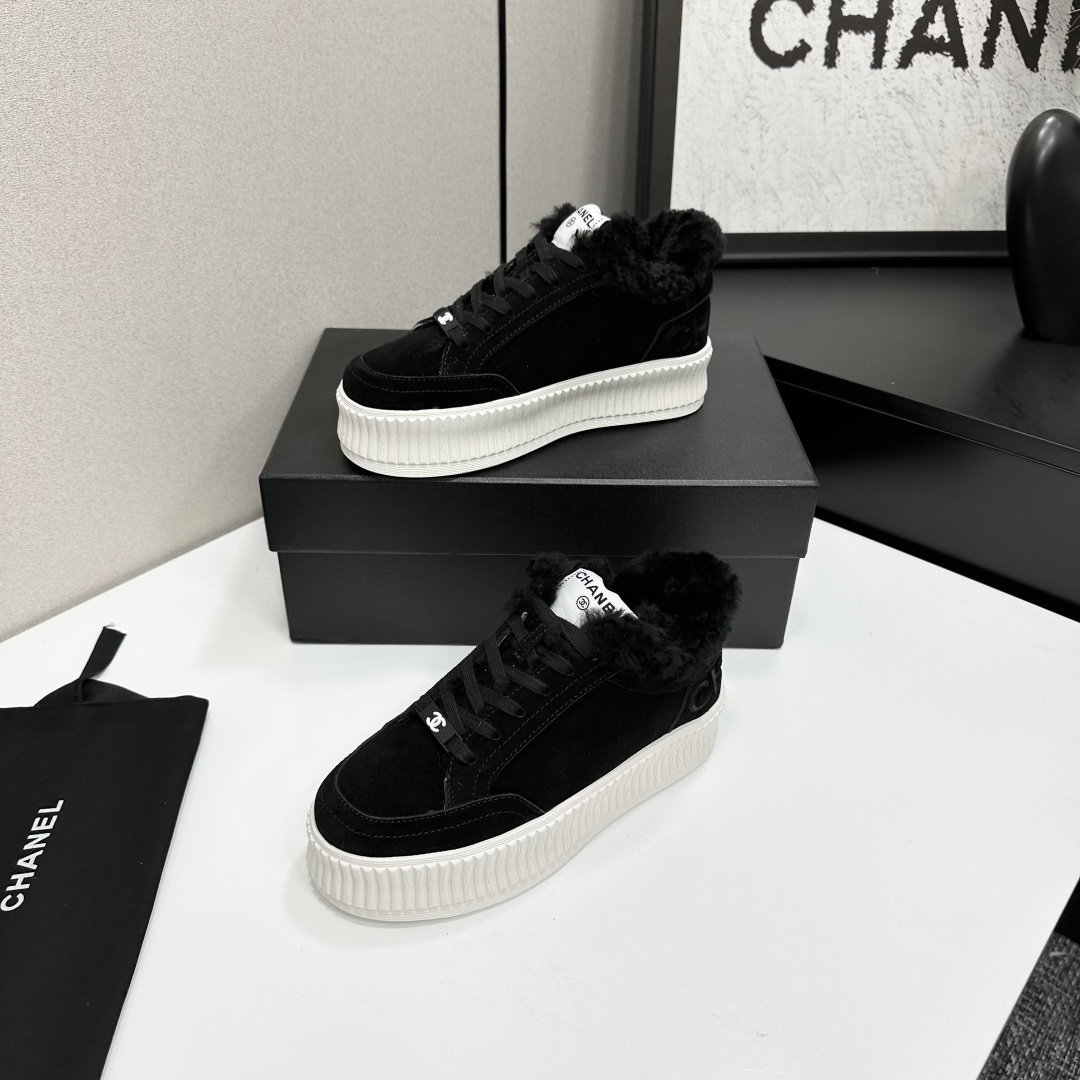 Luxury Chanel black suede sneakers with black fur trim and thick white ribbed platform soles on a black display box. - Hình 2