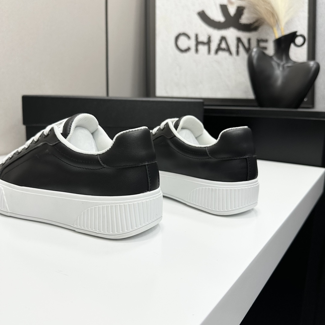 Side view of Chanel black and white platform sneakers with ribbed soles on a black designer box - Hình 7