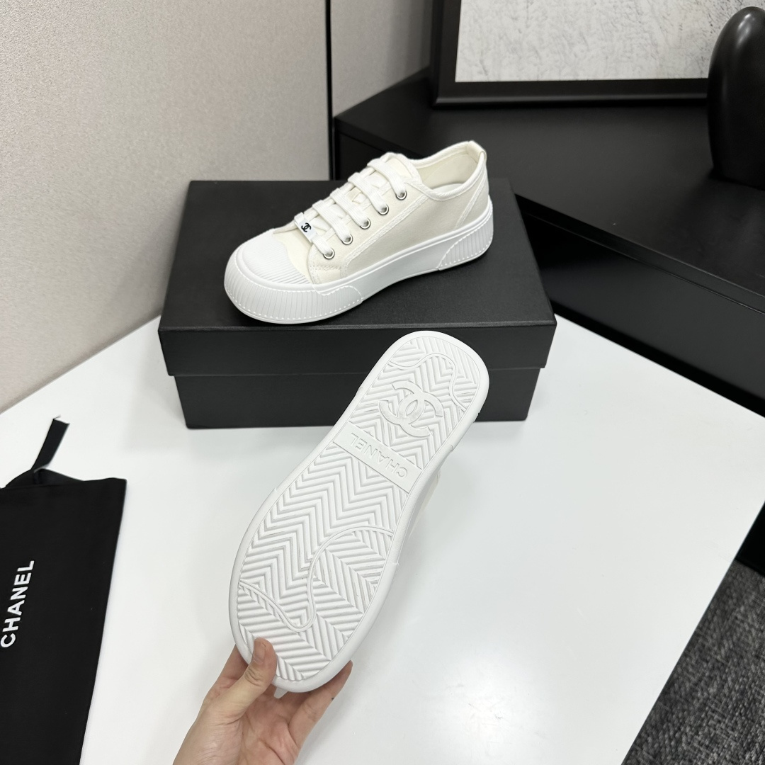 A pair of Chanel white canvas low-top sneakers with a chunky white platform sole resting on a black box. - Hình 4