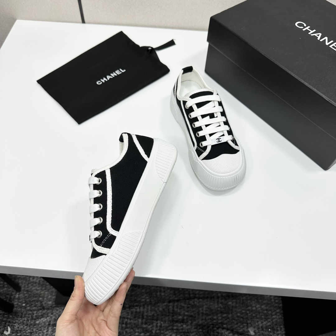 Chanel black and white canvas sneakers with chunky platform ribbed rubber soles displayed on a black box. - Hình 9