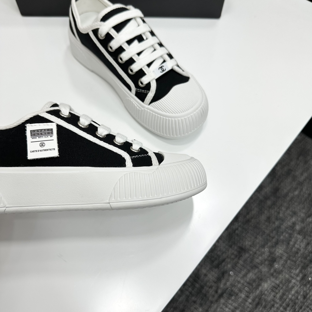 Chanel black and white canvas sneakers with chunky platform ribbed rubber soles displayed on a black box. - Hình 8
