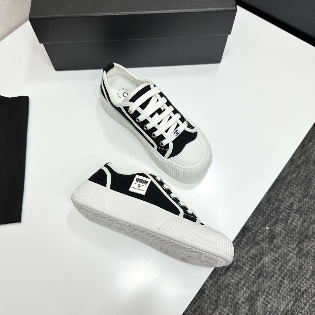 Chanel black and white canvas sneakers with chunky platform ribbed rubber soles displayed on a black box. - Hình 7