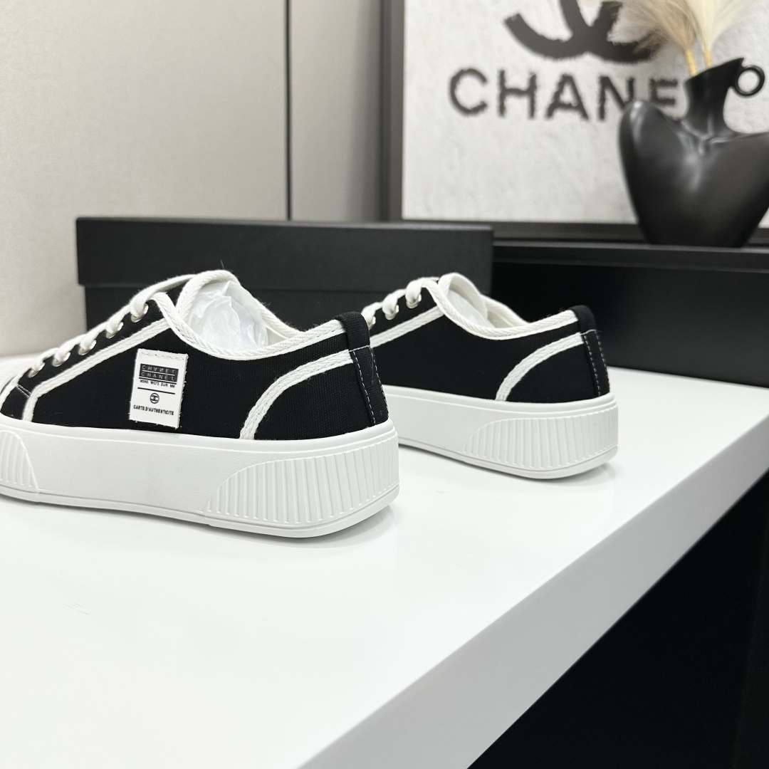 Chanel black and white canvas sneakers with chunky platform ribbed rubber soles displayed on a black box. - Hình 6