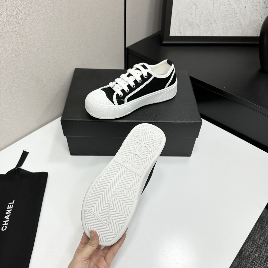 Chanel black and white canvas sneakers with chunky platform ribbed rubber soles displayed on a black box. - Hình 4