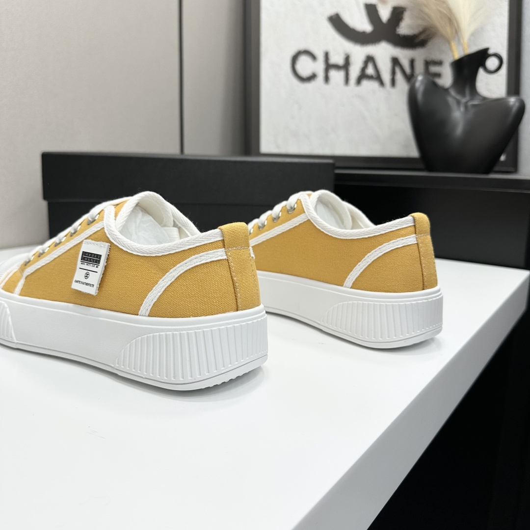 Side view of Chanel yellow canvas platform sneakers with chunky white soles on a black luxury box - Hình 8