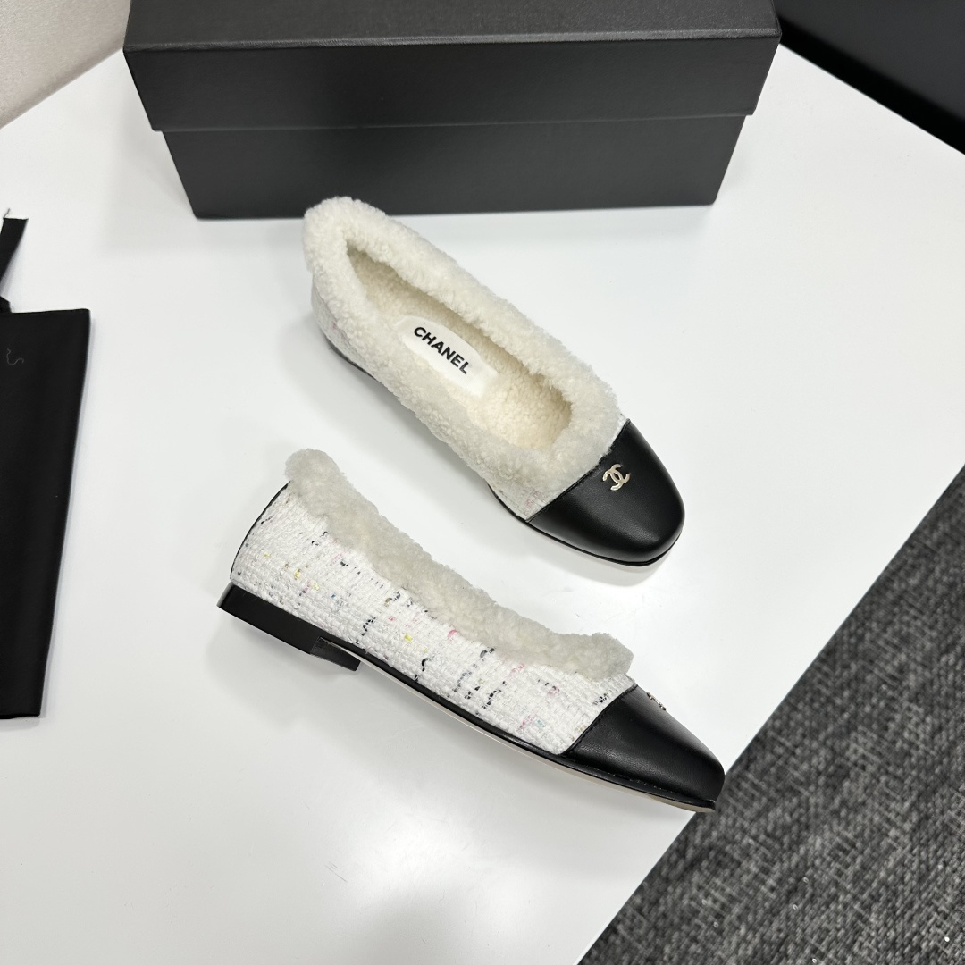 Luxury Chanel white tweed ballet flats with black leather toe caps and white faux fur lining displayed on a black designer box. - Hình 10