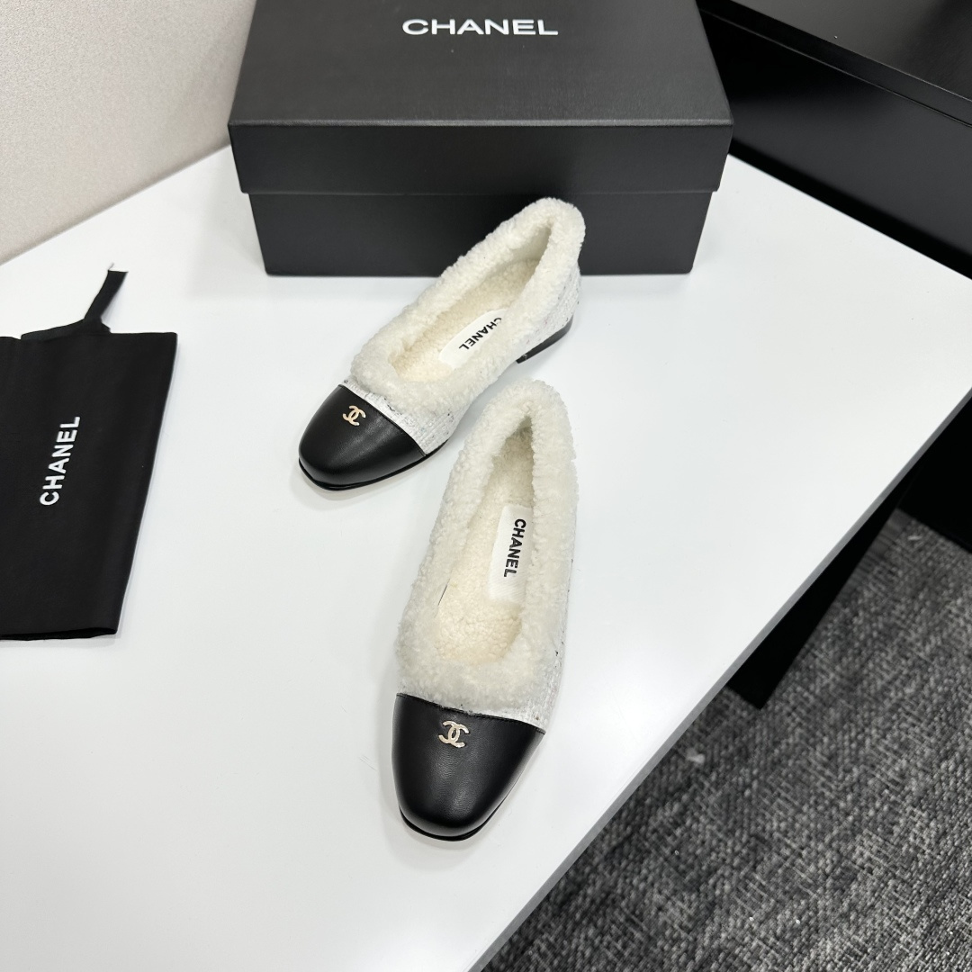 Luxury Chanel white tweed ballet flats with black leather toe caps and white faux fur lining displayed on a black designer box. - Hình 6